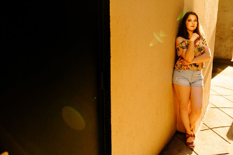 Senior girl leaning against wall on the street in philadelphia posing for photography Kasey Ivan Photography