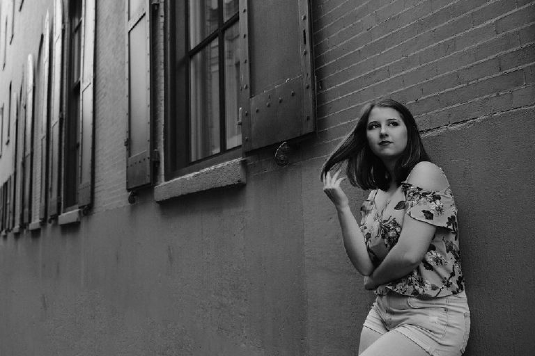 Black and white photograph of a senior girl posing in an allyway in old city Philadelphia