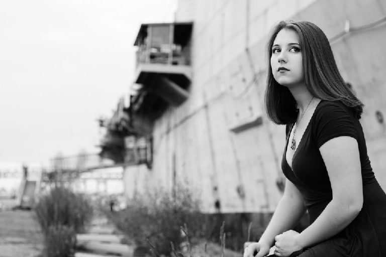 Black and White photograph of a senior girl sitting at the navy shipyard in philadelphia for Kasey Ivan Photography