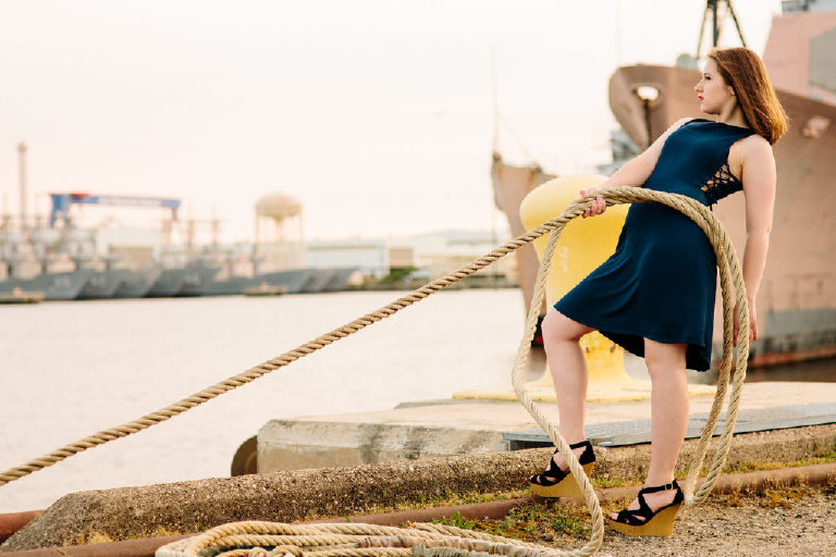Senior girl holding and pulling a rope at the navy shipyard in Philadelphia posing for Kasey Ivan Photography