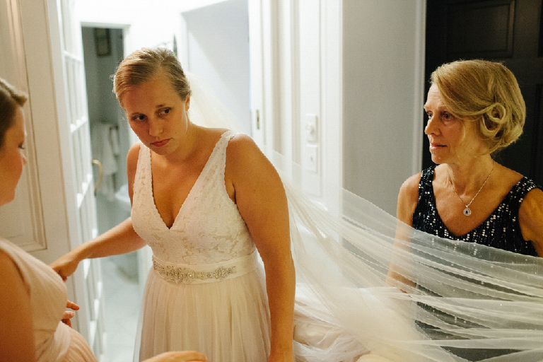 Mother fixing the veil on her daughter helping her get ready for her wedding