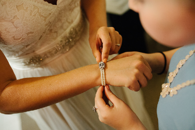 Bride putting on a chic bracelet getting ready fo her wedding at porches on the towpath in New Hope and Lambertville