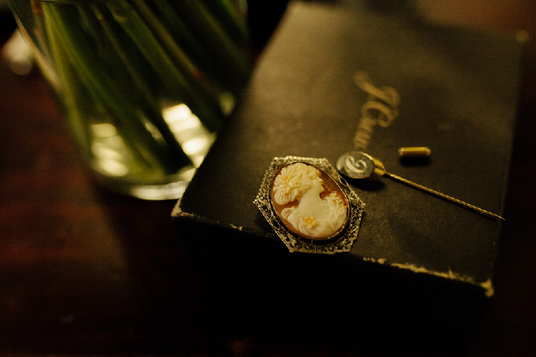 Picture of an old antique brooch on a table in porches on the towpath for a wedding in New Hope