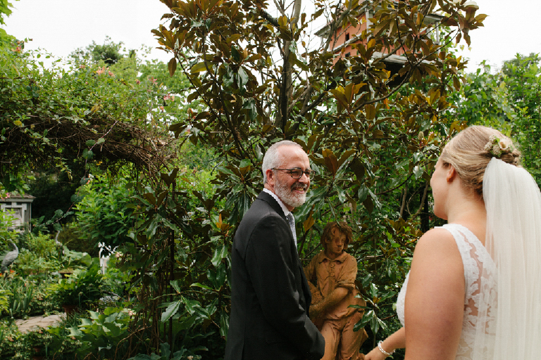 Groom seeing his bride for the first time in a colorful chic garden in the Porches in the Towpath in New Hope