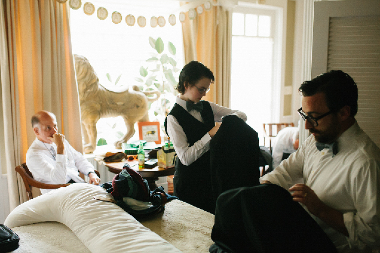 Family getting ready in a room getting dressed in tux for the wedding