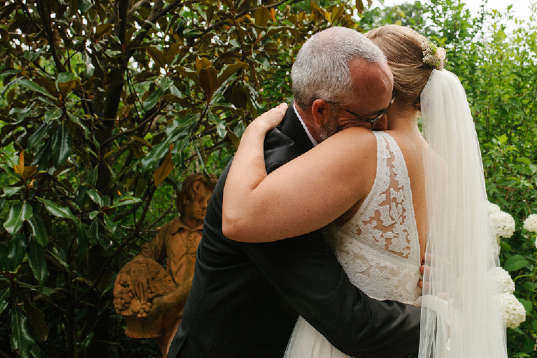 Groom hugging his bride in a garden in the porches on the towpath