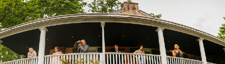 Long photo of family standing on a porch waiting for a Chic wedding in New Hope