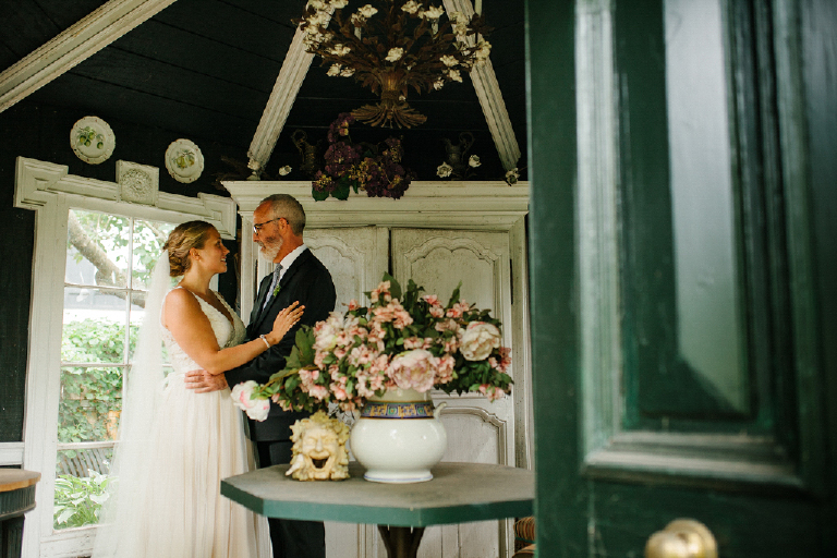 Bride and groom hugging next to colorful flowers in a rustic room in the Porches on the Towpath in New Hope and Lambertville