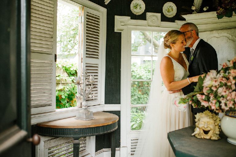 Groom kissing brides cheek and bride laughing in a rustic room at the Porches on the Towpath in New Hope and Lambertville