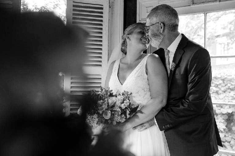 Groom hissing his bride in chic room at the Porches on the Towpath in New Hope and Lambertville