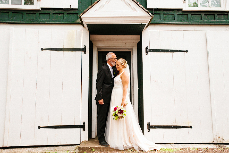 Groom and bride standing infront of a black and white rustic building at the Porches on the Towpath in New Hope and Lambertville