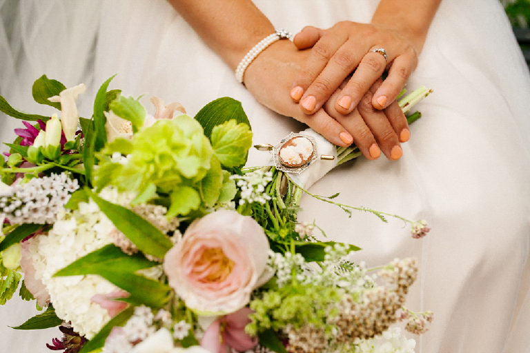 Photograph of brides hands with her bouquet of flowers and ring at the Porches on the Towpath in New Hope and Lambertville
