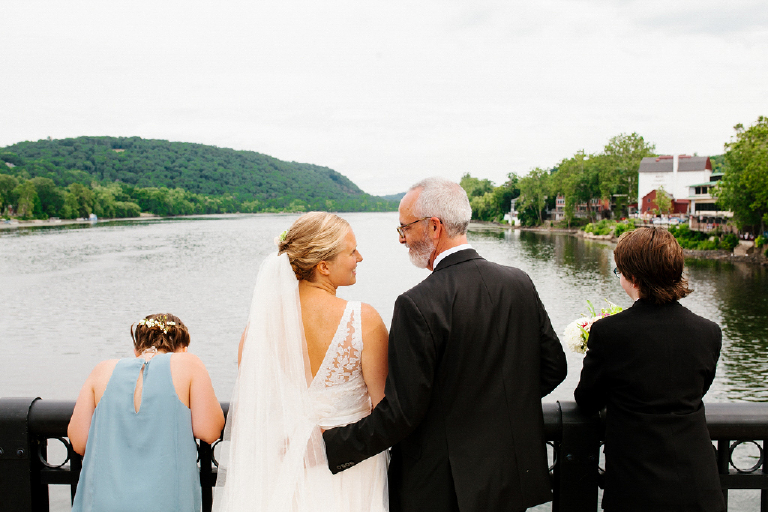 Bride and groom looking out at the delaware river with kids on the New Hope and Lambertville bridge