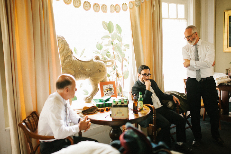 Men sitting around a table talking and getting ready for a wedding 