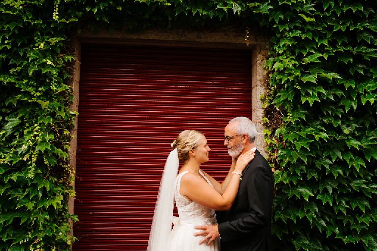 Bride and groom standing infront of rustic wall covererd in ivory in Lambertville New Jersey