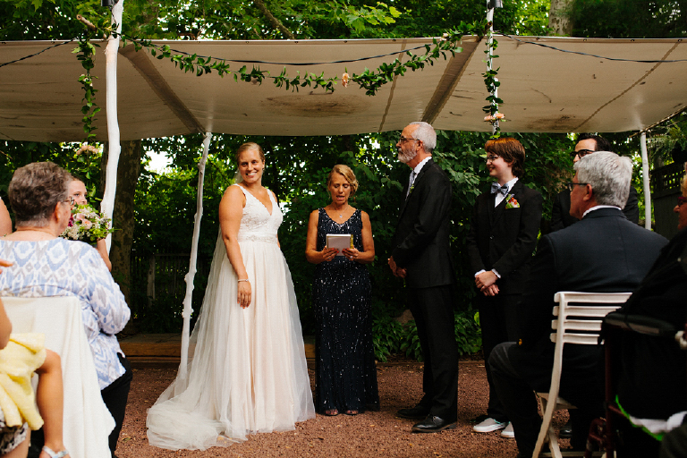 Photograph of bride smiling at her family and wedding guest standing at the alter Hamilton's Grillroom Lambertville New Hope