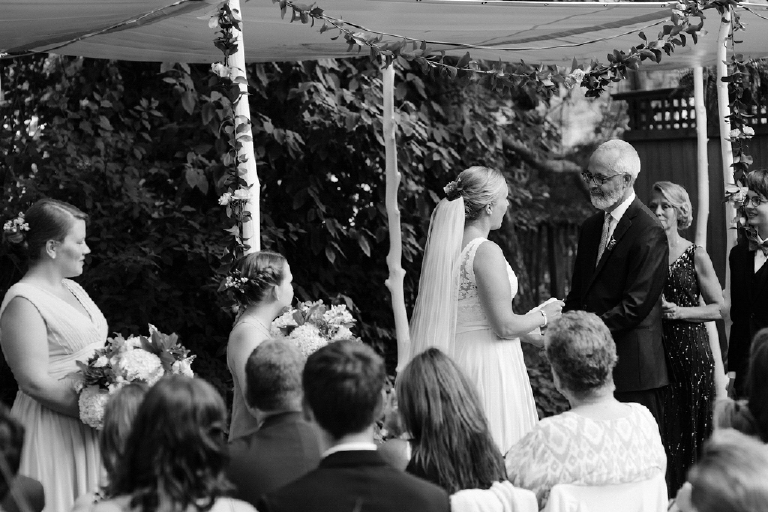 Black and white image of bride and groom holding hands at the alter on their wedding day Hamilton's Grillroom Lambertville New Hope