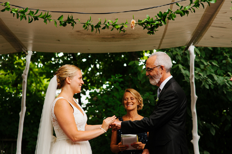Bride and groom holding hands at rustic wedding ceremony with greenery Hamilton's Grillroom Lambertville New Hope