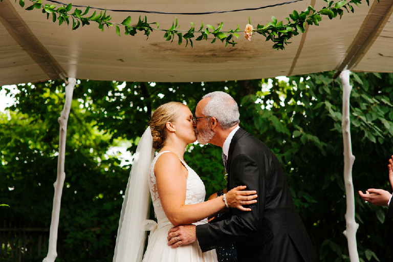 Groom kissing his bride at their wedding ceremony Hamilton's Grillroom Lambertville New Hope