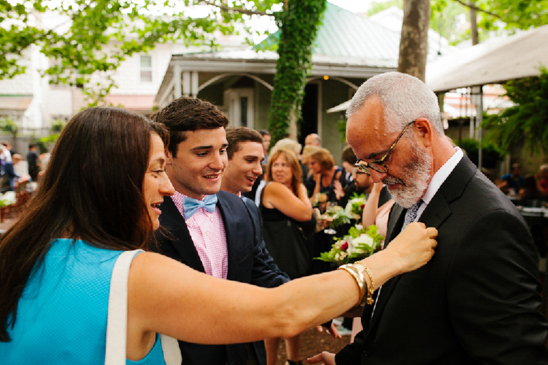 Family member fixes tux of the groom at a chic wedding at Hamilton's Grillroom Lambertville New Hope
