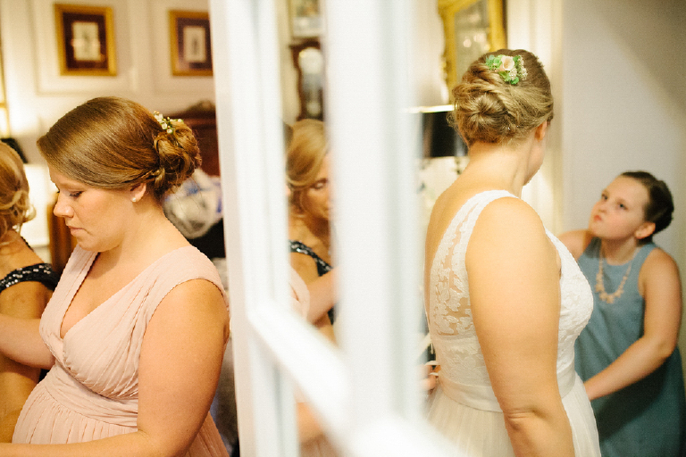 Picture of women in a room getting ready for a wedding bride with colorful flowers in her hair at the Porches on the Towpath in New Hope