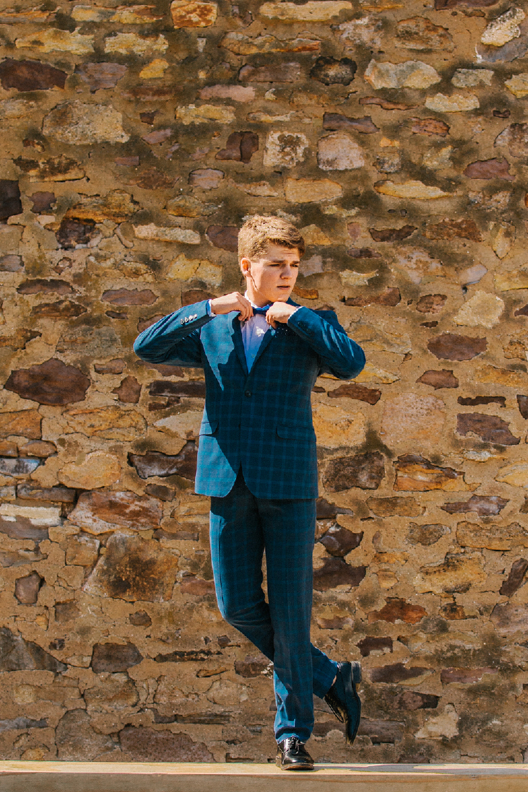 Tyler McClellan poses in GQ inspired senior photos in blue suit in Doylestown Pennsylvania by photographer Kasey Ivan Photography