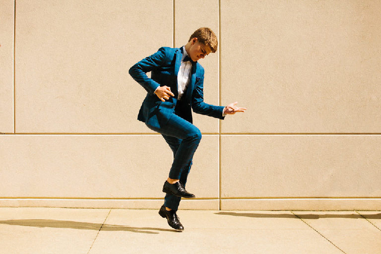 high school senior poses for senior photos in GQ inspired blue suit at Michener Museum in Doylestown Pennsylvania by photographer Kasey Ivan