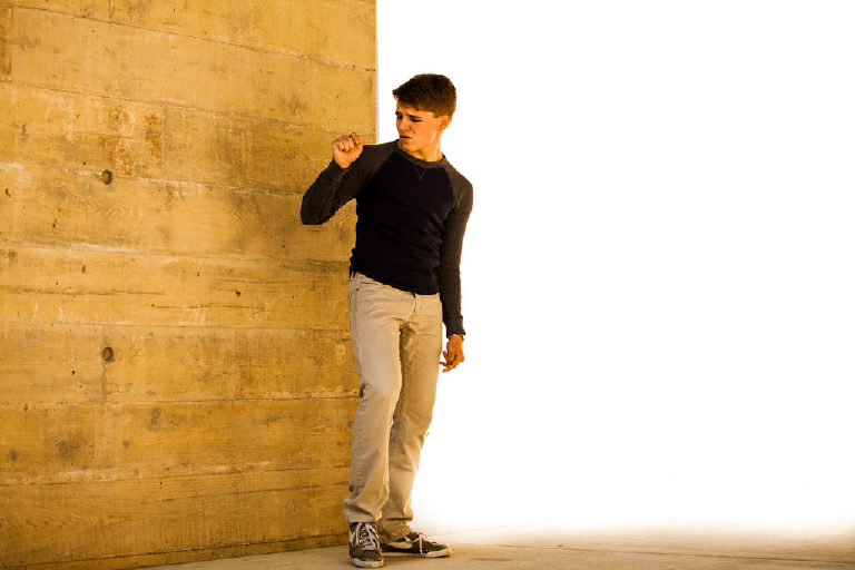 high school senior boy poses outside Mercer Museum in Doylestown Pennsylvania for senior pictures by photographer Kasey Ivan Photography