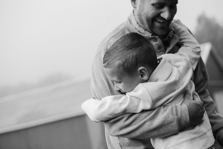 father hugging little boy son for family portrait by New Hope photographer Kasey Ivan