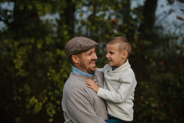 english father laughing at son as he holds him for family portrait by New Hope photographer Kasey Ivan