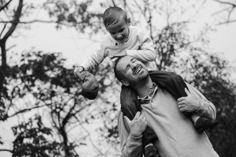 son riding piggyback steals fathers hat lovingly for family portrait by New Hope photographer Kasey Ivan