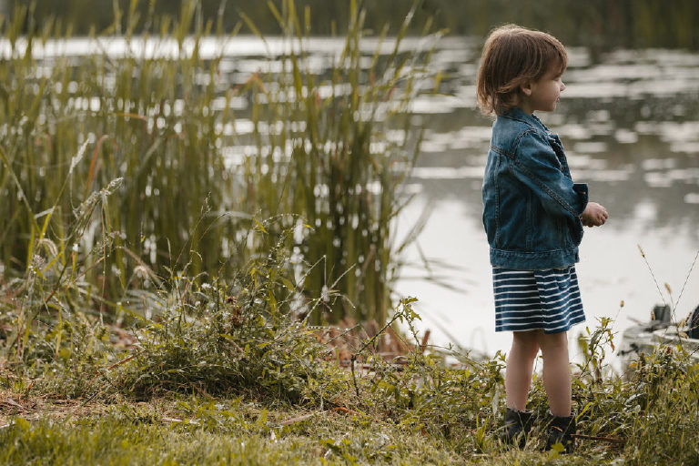little girl looking at pond for family portrait by New Hope photographer Kasey Ivan