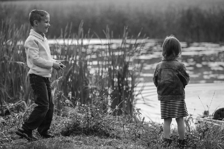 kids play with rocks at pond for family portrait by New Hope photographer Kasey Ivan