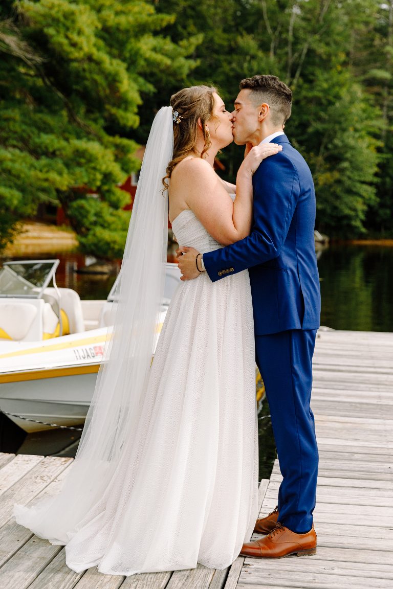 Bride and groom share a kiss on the docks and lake before their wedding ceremony at the Tarry A While Resort in Bridgton Maine