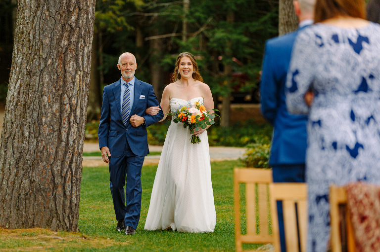 Bride walking down the aisle with her father to the wedding ceremony at the Tarry A While Resort in Bridgton Maine.