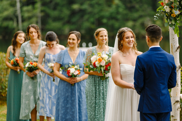 Bride and her bridesmaids smiling at the wedding ceremony at the Tarry A While Resort in Bridgton Maine